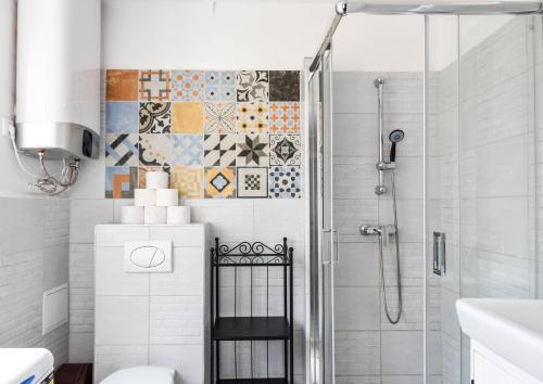 baño con ducha con azulejos en la pared en Diamond Astoria Apartments, en Budapest