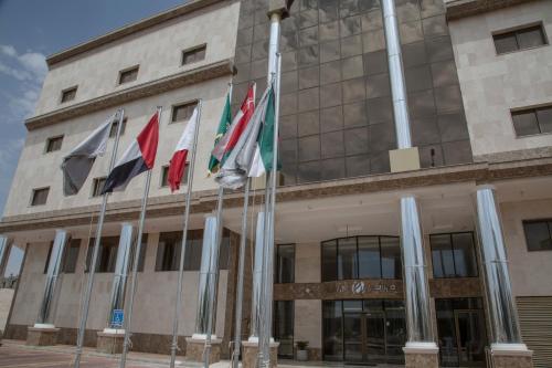 a group of flags in front of a building at شقق مساكن الزمرد للشقق المخدومة in Yanbu
