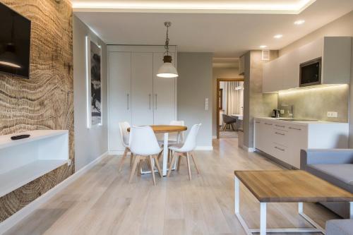a kitchen and living room with a table and chairs at Royal Hill Residence in Zakopane