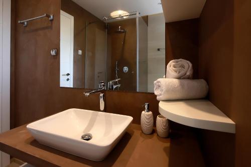 a bathroom with a white sink and a mirror at MODENA MARIS-heated pool-grill-relax-jacuzzi apartments in Ičići
