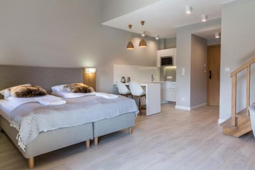 a bedroom with a large bed and a kitchen at Royal Hill Residence in Zakopane