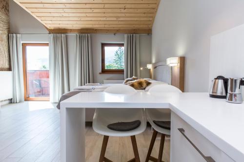 a kitchen with a table and two white chairs at Royal Hill Residence in Zakopane