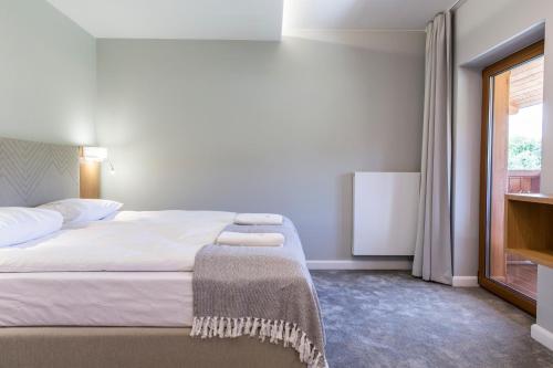 a bedroom with a large bed and a window at Royal Hill Residence in Zakopane