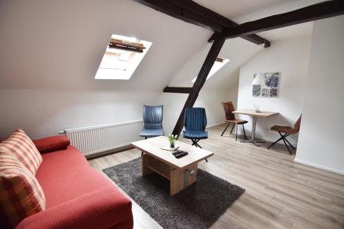 sala de estar con sofá rojo y sillas azules en Ferienwohnung Troisdorf en Troisdorf