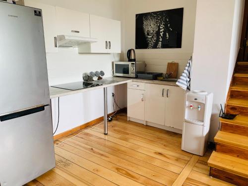 a small kitchen with white cabinets and a refrigerator at Pokoje Slawin in Lublin