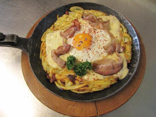 a plate of food with eggs and sausage on pasta at Hotel-Restaurant le Relais Panoramique in Les Crosets
