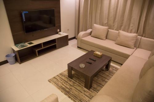 a living room with a couch and a coffee table at شقق مساكن الزمرد للشقق المخدومة in Yanbu