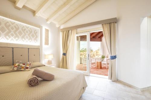 a bedroom with a bed and a door to a patio at Corte Bianca - Adults Only & SPA - Bovis Hotels in Cardedu