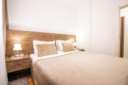 a bedroom with a large bed with a wooden headboard at Thomas Residence in Belgrade