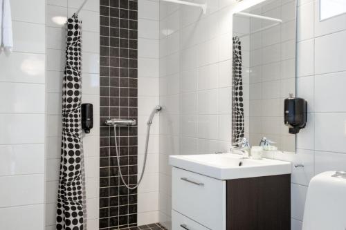 a bathroom with a shower with a sink and a shower at EttSmart Hotell in Sollentuna