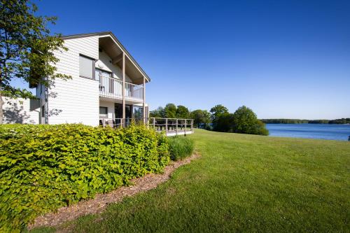 a house on a hill next to the water at Golden Lakes Village Ardennes in Boussu-lez-Walcourt