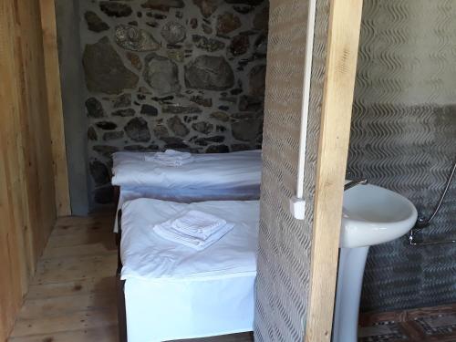 a small room with a bed and a sink at Guest House Murkvam in Tvebishi
