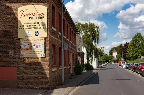 een bord aan de zijkant van een bakstenen gebouw bij Landhaus Pohlhof in Keulen