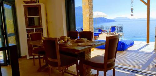 a dining room with a table and a view of the water at Villa LeSunLuka Lefkada in Vasiliki