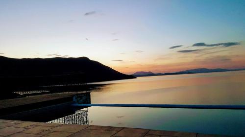 a body of water with a sunset in the background at Villa LeSunLuka Lefkada in Vasiliki