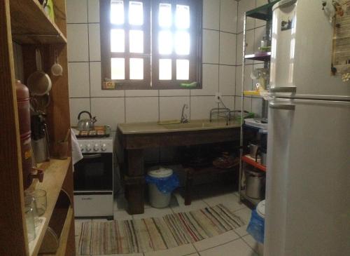 een kleine keuken met een wastafel en een koelkast bij Chácara Canto da Mata in Cavalcante