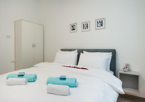 a white bed with towels on top of it at Balfour sea view city center in Nahariyya