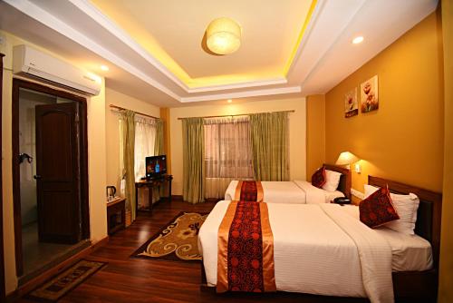 a hotel room with two beds and a television at DOM Himalaya Hotel in Kathmandu