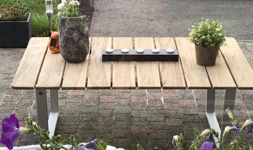 a wooden picnic table with two potted plants on it at Ferme de la Petite Fagne in Spa