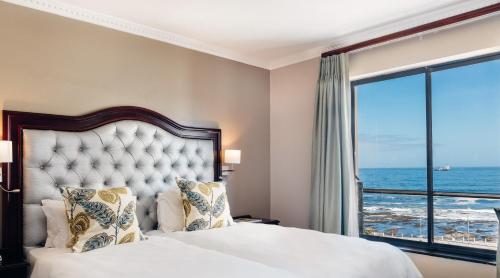 a bedroom with a bed with a view of the ocean at Premier Hotel Cape Town in Cape Town