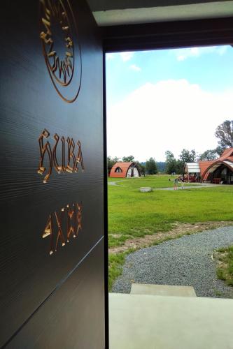 a door with a sign on it next to a field at Hunnia - Huntanya in Vlăhiţa