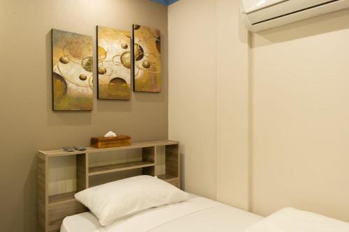 um quarto com uma cama e pinturas na parede em Hotel Styled Apartment in Heart of Quatre Bornes em Quatre Bornes