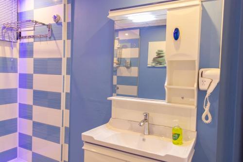 ein Bad mit einem Waschbecken und einem Spiegel in der Unterkunft Hotel Styled Apartment in Heart of Quatre Bornes in Quatre Bornes