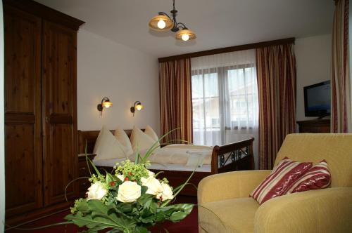a living room with a couch and a bedroom at Pension Heidi in Kaprun