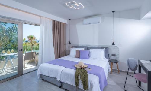 a white bedroom with a bed with a hat on it at CHC Imperial Palace Adults Only in Adelianos Kampos