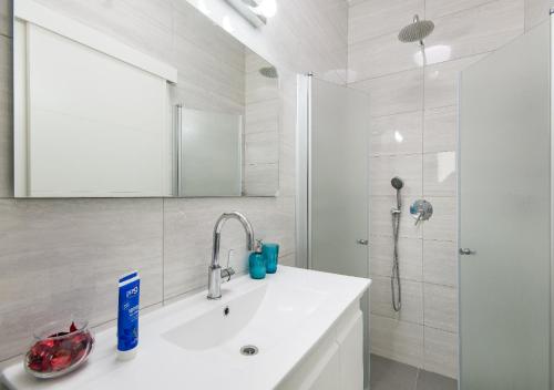 a bathroom with a sink and a mirror and a shower at Balfour sea view city center in Nahariyya