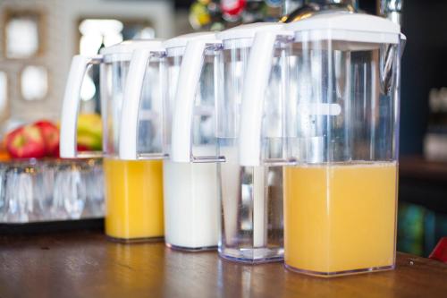 three containers of orange juice sitting on a table at The House of Toby in London