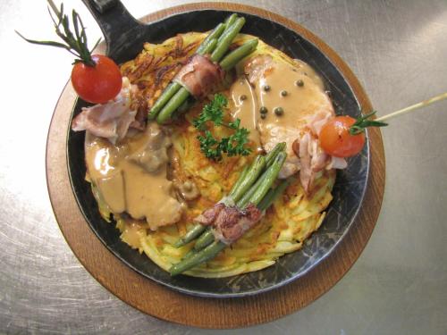a bowl of food with meat and vegetables on a table at Hotel-Restaurant le Relais Panoramique in Les Crosets
