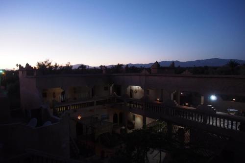 a view of a building with the sunset in the background at Kasbah Dar Dmana in Skoura