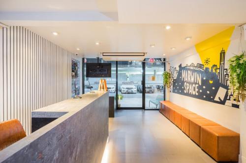 a lobby of a restaurant with a counter and benches at Marwin Space in Bangkok