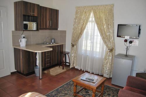 a kitchen with a sink and a table in a room at Welcome Guest House in Vereeniging