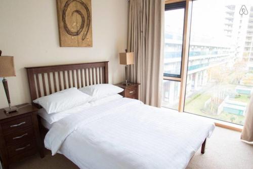 a bedroom with a large bed and a large window at The Edges A2B in Sandyford