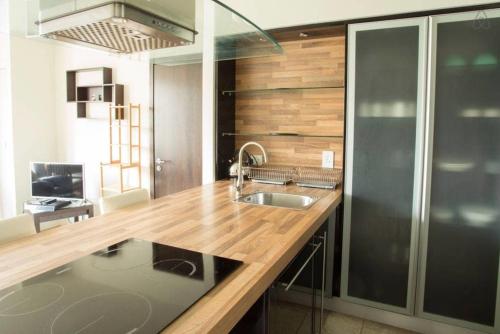 cocina con fregadero y encimera de madera en The Edges A2B en Sandyford