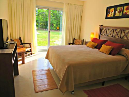 een slaapkamer met een groot bed en een groot raam bij Petit Chateau Hotel Boutique in Punta del Este