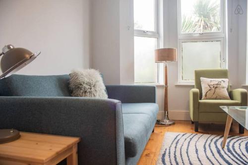 a living room with a blue couch and two chairs at Rugby Lodge in Dublin