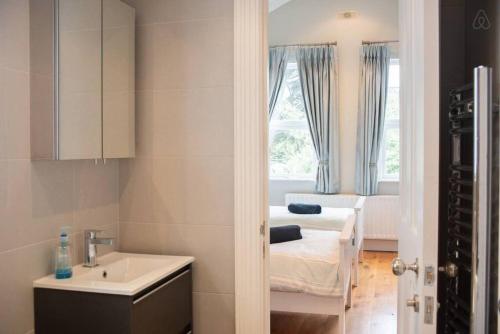 a bathroom with a sink and a room with a couch at Rugby Lodge in Dublin