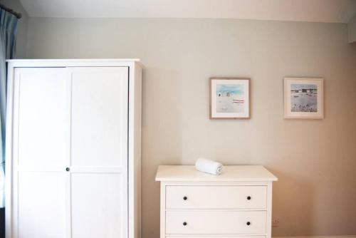 a bedroom with a white cabinet and a white dresser at Rugby Lodge in Dublin