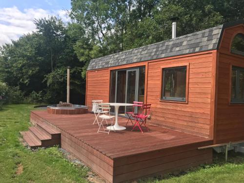 a wooden deck with a table and chairs on it at TinyHouse on the prairie in Mehaigne