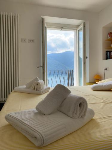 two beds with towels on them in a room with a window at La Filanda di Viano in Tremezzo