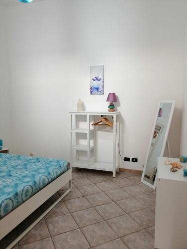 a bedroom with a bed and a table and a shelf at A casa di Vale in Cava D'aliga