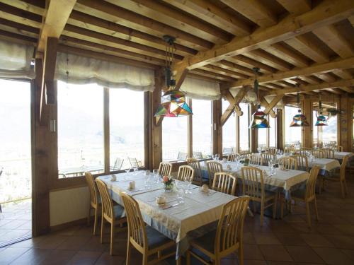 un comedor con mesas, sillas y ventanas en Albergo Deva, en Riva del Garda