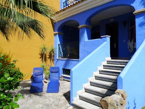 une maison bleue et jaune avec des escaliers menant à une porte dans l'établissement Belvilla by OYO La Casa Az l, à Zahara de los Atunes