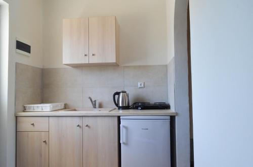 kuchnia z białymi szafkami i blatem w obiekcie Sevi Apartments w mieście Kefalos