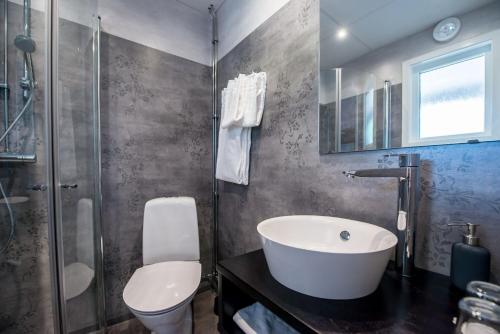 a bathroom with a sink and a toilet and a shower at Gylle Hotell & Restaurang Brödernas in Borlänge