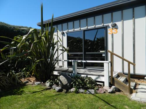 a small house with a porch and a window at Taupo Debretts Spa Resort in Taupo