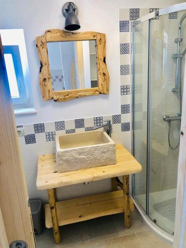 a bathroom with a sink and a mirror and a shower at Trulli Paradise Alberobello in Alberobello